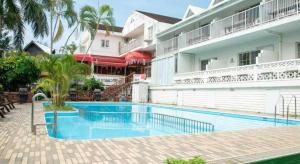 a hotel with a swimming pool in front of a building at Petit Hotel Key West Club in Inbu +37 photos