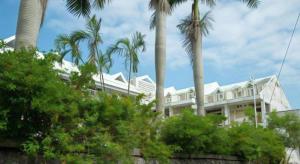 a large white house with palm trees in front of it at Petit Hotel Key West Club in Inbu