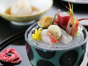 un plato de comida con sushi en una mesa en Shiratamano Yu Kahou, en Shibata