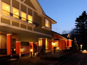a building with a bench in front of it at night at Pension Twilight in Nasu-yumoto