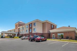 a parking lot with cars parked in front of a building at Comfort Suites Urbana Champaign, University Area in Champaign