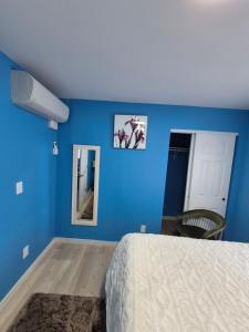 a bedroom with blue walls and a bed and a mirror at Work & Lake Guest house at Airport in SeaTac