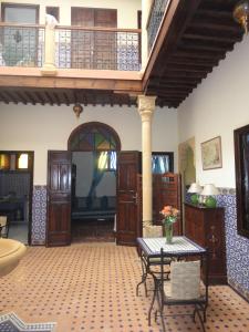 a living room with a table and a balcony at Dar Yanis in Rabat