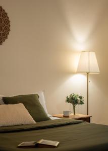 a bedroom with a bed with a lamp and a plant at Chetty's Mane by Raho - Estate-View Heritage Stay in Siddapur