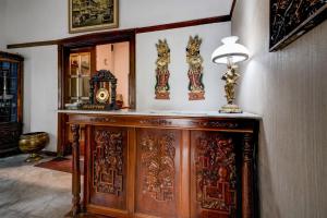 バンドンにあるHotel O Bandung near Stadion Siliwangi formerly The Ethnic Hotel Bandungの木製のキャビネット(時計付)が備わる客室です。