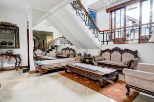 バンドンにあるHotel O Bandung near Stadion Siliwangi formerly The Ethnic Hotel Bandungのソファ2つと階段のあるリビングルーム