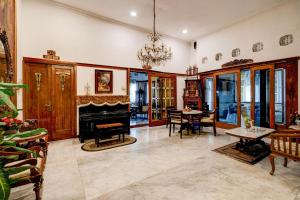 バンドンにあるHotel O Bandung near Stadion Siliwangi formerly The Ethnic Hotel Bandungの暖炉とテーブルと椅子のあるリビングルーム