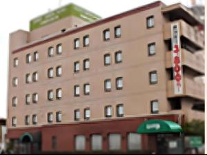 a tall brick building with a sign in front of it at Odate Green Hotel in Odate