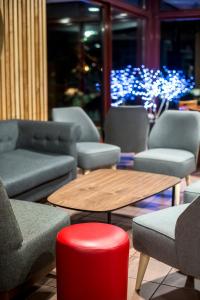 a room with couches and a table with a red stool at Villages Clubs du Soleil - LES KARELLIS in Montricher-Albanne