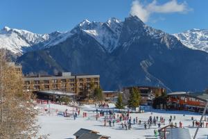 a group of people on a ski slope in front of mountains at Villages Clubs du Soleil - LES KARELLIS in Montricher-Albanne