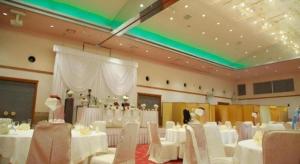 a banquet hall with white tables and white chairs at AKISAWA HOTEL in Sukumo
