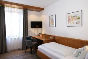 a hotel room with a bed and a desk at Gasthof zur Post Oberwirt in Chieming