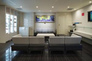 a room with chairs and a table and a refrigerator at JR-EAST HOTEL METS NAGAOKA in Nagaoka