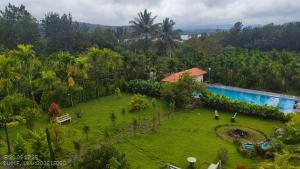 an aerial view of a garden with a swimming pool at Coorg Riverness Resort in Kushālnagar