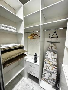 a walk in closet with a surfboard in it at Sky Apartment Bolashak in Aktobe