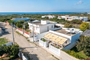 Vue aérienne d'une maison avec l'océan en arrière-plan dans l'établissement Lèvè – Sea Nature Stay, à Torre Lapillo