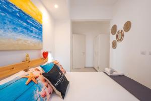 une chambre avec un lit et un tableau au mur dans l'établissement Lèvè – Sea Nature Stay, à Torre Lapillo