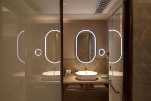 a bathroom with two sinks and two mirrors at Mercure Xi'an History Museum in Xi'an +16 photos