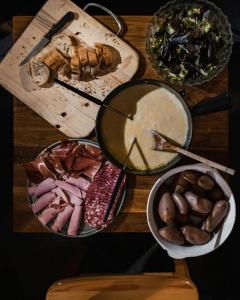 a wooden table topped with different types of food at Chalet Sainte Anne in Condamine-Châtelard +3 photos