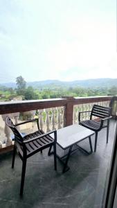 two chairs and a table on top of a balcony at Hotel Rajmahal Palace Bhimashankar pune in Taleghar