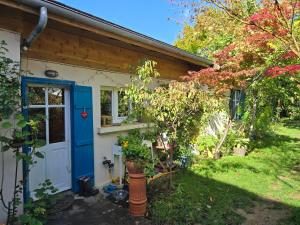 une petite maison avec une porte bleue et une cour dans l'établissement Le Clos du Moulin Dijon , au calme,proche centre ville, la campagne à la ville, à Dijon