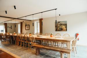 a large dining room with a large wooden table and chairs at La Source du Lodji by WelcHome in Spa