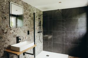 a bathroom with a sink and a shower at La Source du Lodji by WelcHome in Spa