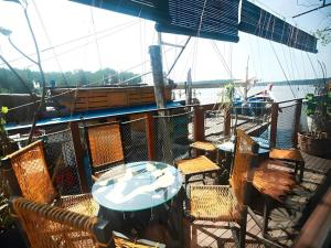 a table and chairs on a deck of a boat at The Happy 8 Retreat @ Kuala Sepetang in Kampung Sepetang