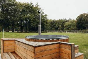 a fire pit in the middle of a field at La Source du Lodji by WelcHome in Spa