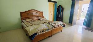a bedroom with a wooden bed in a green room at Jawai Dam Stay and Leopard Safari  +7 photos