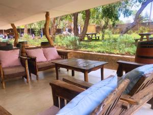 d'une terrasse avec des bancs, une table et des chaises. dans l'établissement Crafted Africa Guest House, à Lilongwe