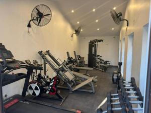 une salle de sport avec plusieurs tapis de course et machines cardio dans l'établissement Crafted Africa Guest House, à Lilongwe