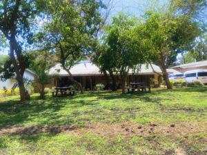une maison avec deux tables de pique-nique dans une cour dans l'établissement Crafted Africa Guest House, à Lilongwe 4 autres photos