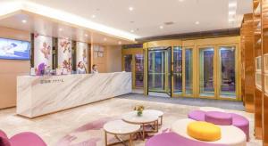 a lobby with purple and yellow chairs and a counter at Lavande Hotel Ji'nan Railway Station Long Distance Bus Terminal in Jinan