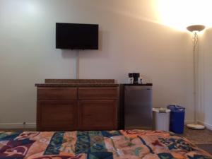 a bedroom with a bed and a television on a wall at Carleton Motel and Coffee Shop in Borden-Carleton