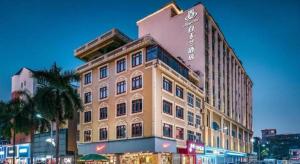 a large building with a sign on top of it at Magnotel Hotel Dongxing Guomen Port in Tung-hsing-shih