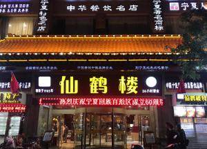 a building with neon signs in front of it at Shell Hotel Yinchuan Xingqing District Yuhuangge Street in Yinchuan