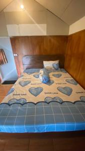 un letto con una coperta blu con dei cuori sopra di Rinjani Edelweis Homestay a Tetebatu