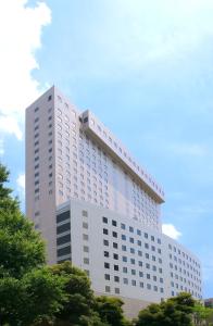 東京にある第一ホテル両国の白い高い建物の前に木々