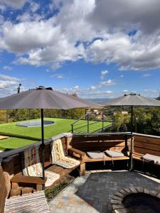 a patio with two chairs and two umbrellas at Restful Haven 