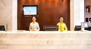 two men sitting at a desk in a lobby at City Comfort Inn Nanning Jinhu Plaza Langxi Metro Station Exhibition in Nanning