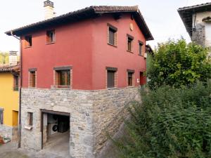 a red house with a stone wall at El Rincon de Onís in Bobia de Abajo