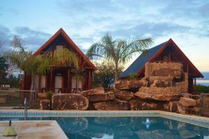 a resort with a swimming pool and a house at Complejo Cascadas de Artalaz in Colón