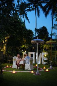 un homme et une femme assis à une table dans un jardin dans l'établissement Ananda Ubud Resort, à Ubud 166 autres photos