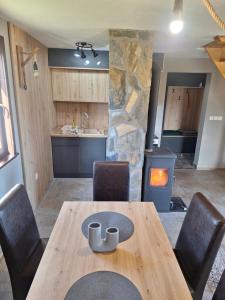 a wooden table and chairs in a kitchen with a fireplace at Planinska kuća Radulović in Goč