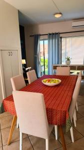 a dining room table with a plate of fruit on it at Creative 2 Level Townhouse Near City and Wine Route in Brackenfell