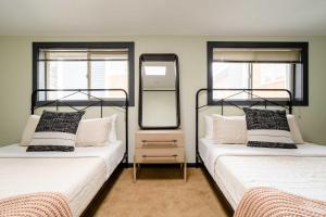 two beds in a room with two mirrors at Stay Portland - Moab Vibes in PDX- Walk to Local Coffee & Food in Portland