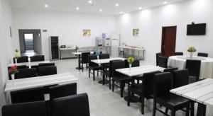 a dining room with white tables and black chairs at GreenTree Inn JiangSu DingShu Twon JieFang(E) Road Express Hotel in Zhoushu