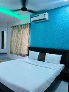 ein Schlafzimmer mit einem Bett mit einer blauen Wand in der Unterkunft Hotel G7 in Indore