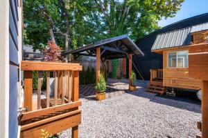 a cabin with a black awning next to a house at Stay Portland - Restored Farmhouse & Backyard Tiny House Village in Portland